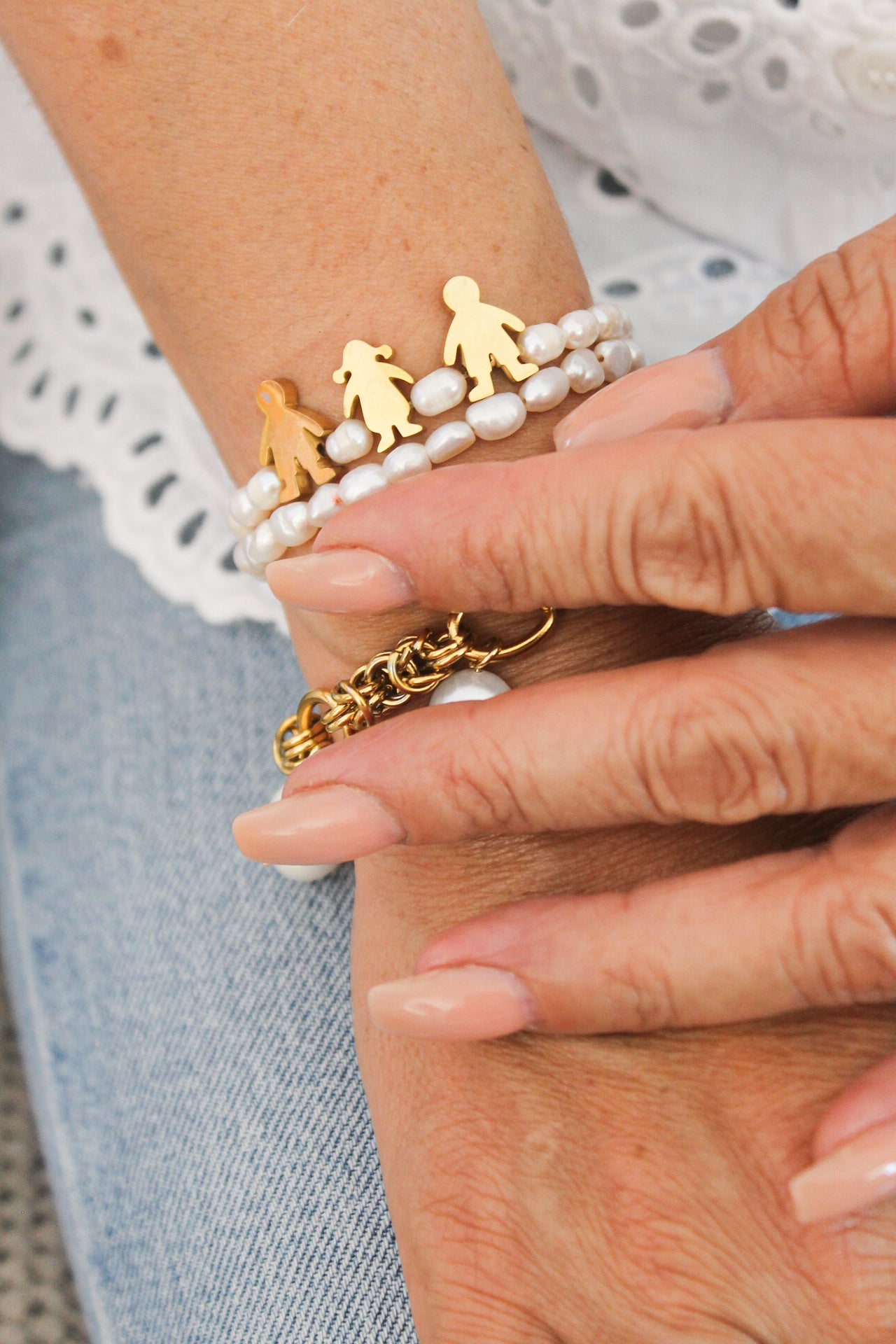 Pulsera de perlas con dijes de niños