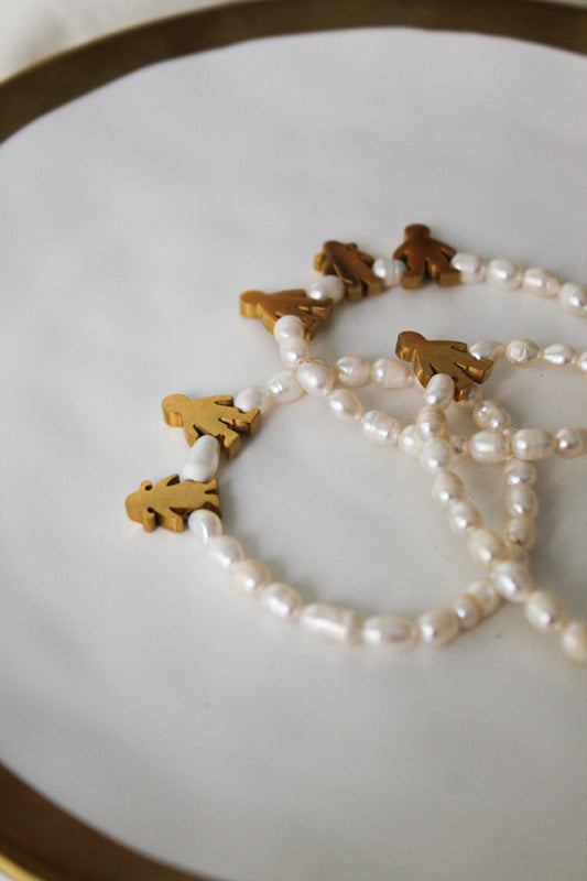 Pulsera de perlas con dijes de niños